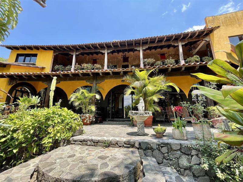 The yellow two-storey villa with arched patio and garden courtyard